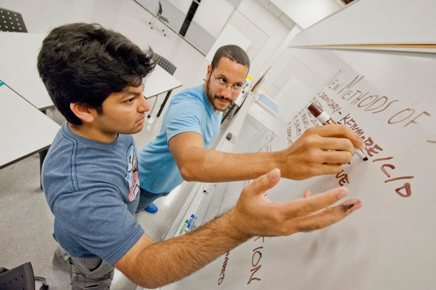 two students working at a whiteboard