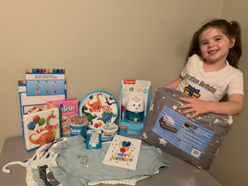 Shelby-Ann poses with the supplies from a birthday kit.